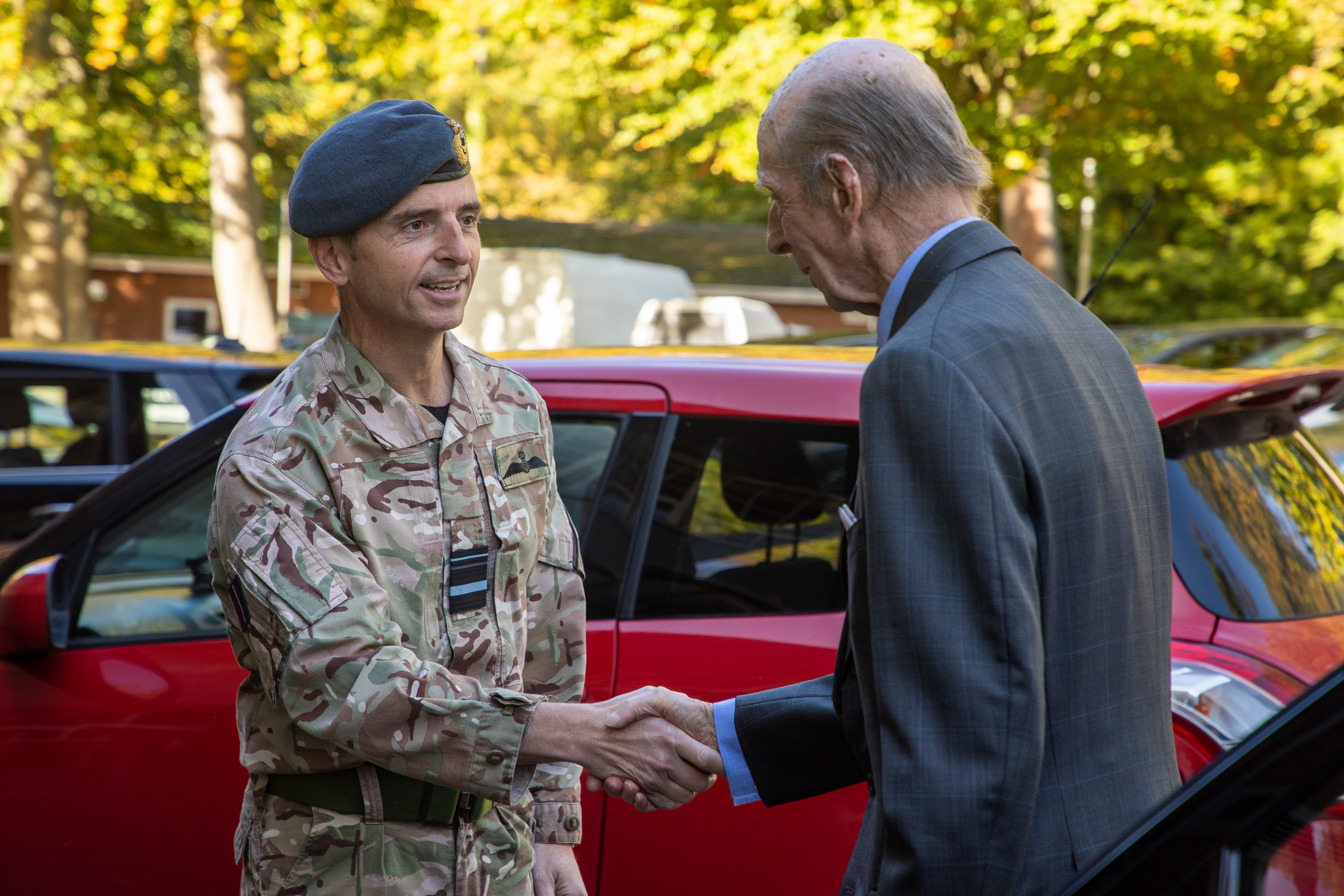 Image shows The Duke of Kent shaking hands with RAF personnel by car.